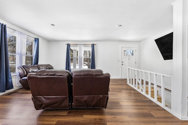 living room featuring a wealth of natural light, dark wood-type flooring, and visible vents