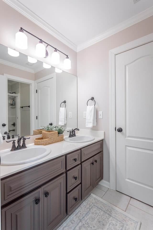 bathroom with ornamental molding, tile patterned flooring, a sink, and double vanity