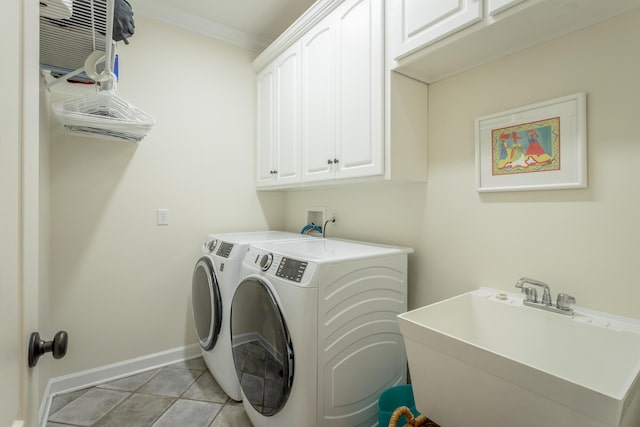 laundry area with cabinet space, light tile patterned floors, baseboards, independent washer and dryer, and a sink