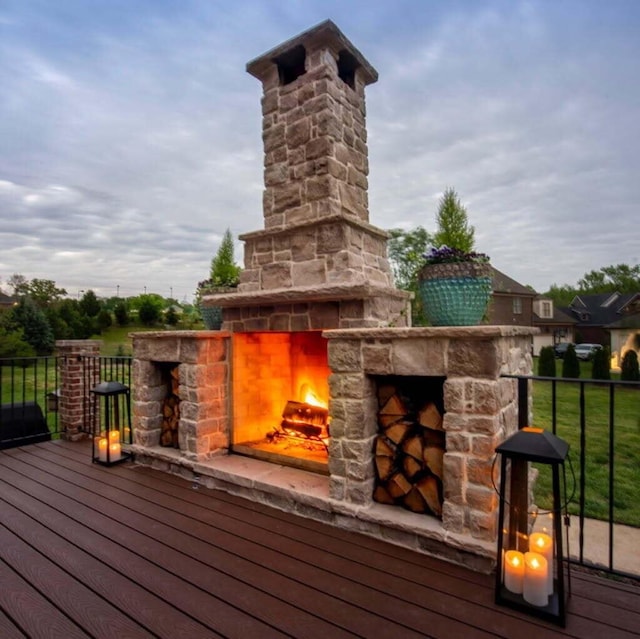 wooden terrace featuring an outdoor stone fireplace