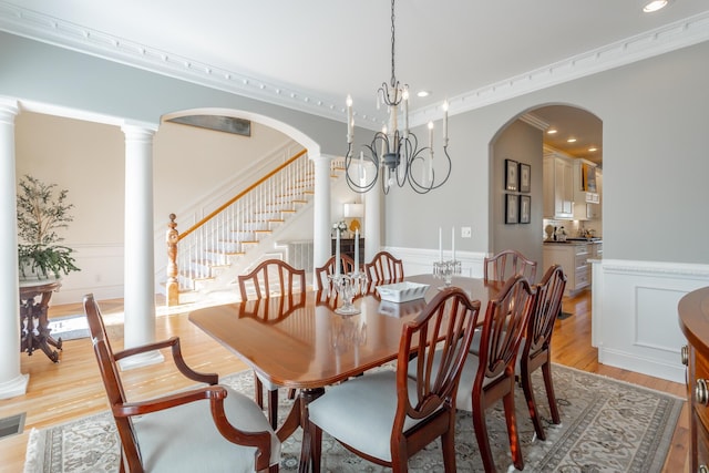 dining area with arched walkways, wainscoting, and ornate columns