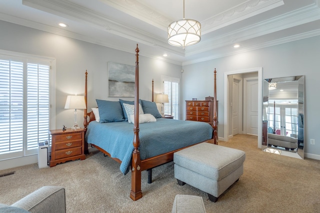 bedroom featuring a tray ceiling, light carpet, and multiple windows