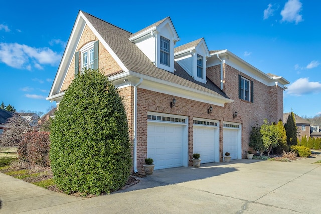 view of home's exterior featuring driveway, roof with shingles, a garage, and brick siding