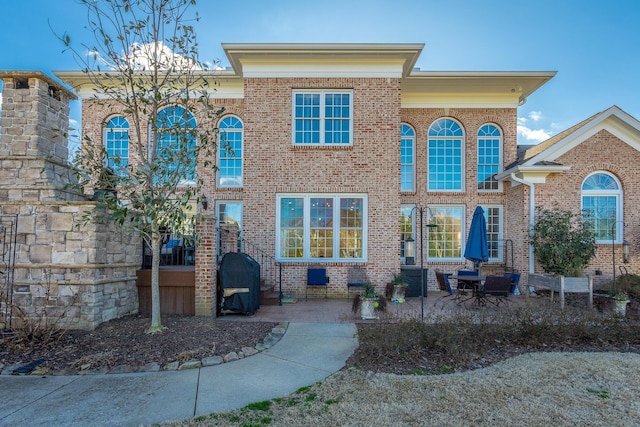 view of front of house featuring crawl space, a patio area, and brick siding