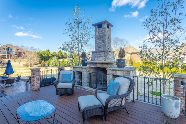 wooden deck with an outdoor stone fireplace