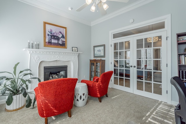 living area with a fireplace, carpet flooring, a ceiling fan, ornamental molding, and french doors