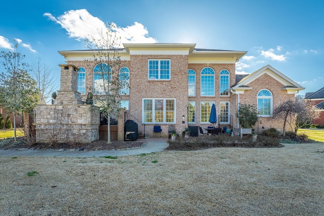 view of front of property featuring a front yard, crawl space, and brick siding