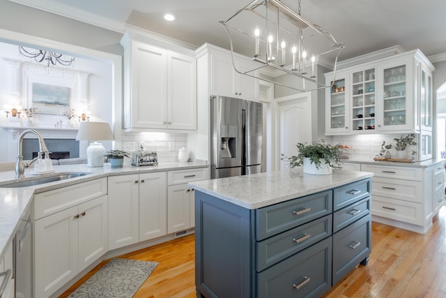 kitchen featuring glass insert cabinets, stainless steel refrigerator with ice dispenser, a sink, and white cabinetry