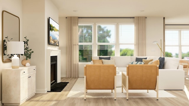 living area with a fireplace with flush hearth, a healthy amount of sunlight, and light wood-style flooring