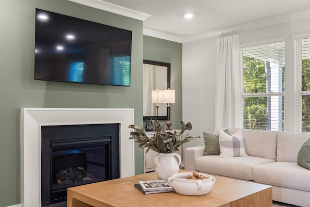 living room featuring a glass covered fireplace, crown molding, and recessed lighting