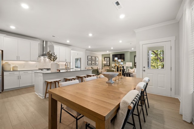 dining room with crown molding, recessed lighting, visible vents, and light wood-style floors