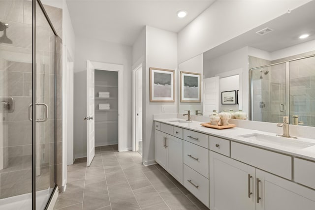 full bathroom with double vanity, a shower stall, and a sink