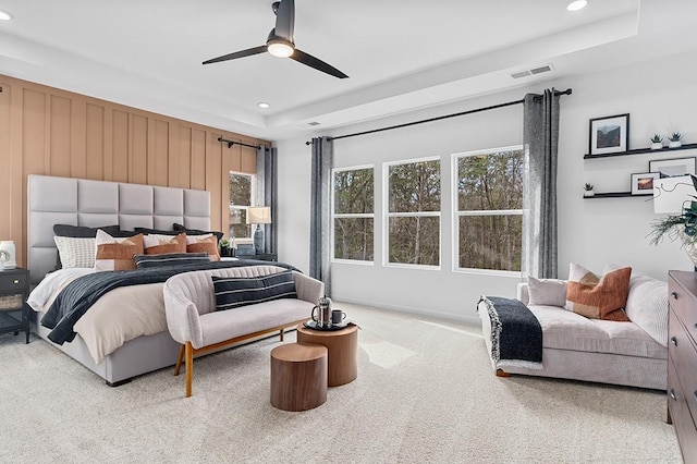 carpeted bedroom with a ceiling fan, a raised ceiling, recessed lighting, and visible vents