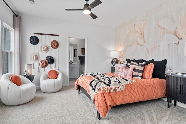 bedroom with ensuite bath, carpet, visible vents, and ceiling fan