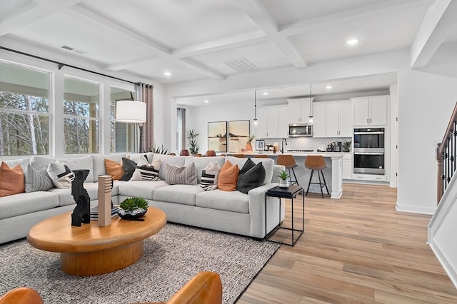 living area with baseboards, coffered ceiling, recessed lighting, light wood-style floors, and beamed ceiling