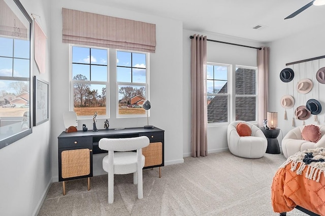 carpeted home office with plenty of natural light, ceiling fan, visible vents, and baseboards