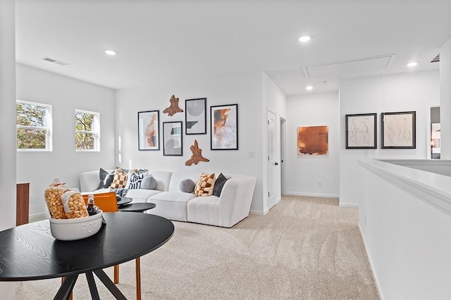 living area featuring recessed lighting, visible vents, light colored carpet, and attic access