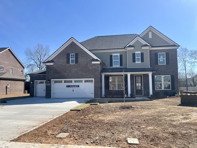 traditional home with concrete driveway, an attached garage, and brick siding