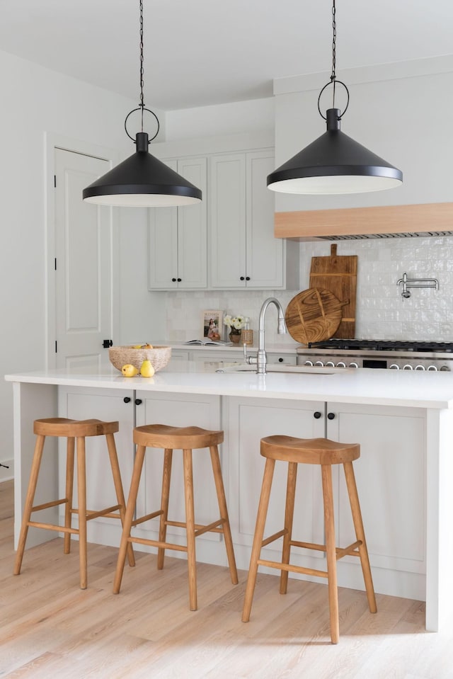 kitchen featuring light countertops, hanging light fixtures, and a breakfast bar