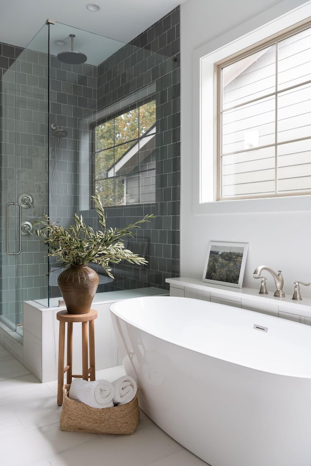 full bathroom with tile patterned flooring, a shower stall, and tile walls