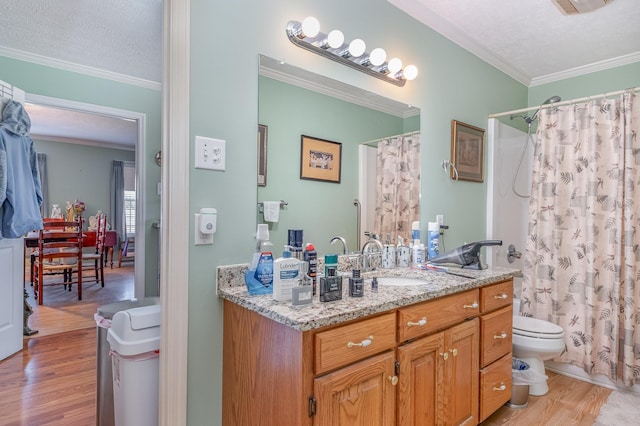 bathroom featuring toilet, a textured ceiling, ornamental molding, and wood finished floors