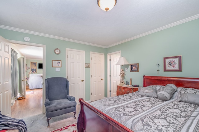 bedroom featuring light wood finished floors, ornamental molding, and a closet