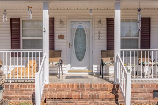 view of exterior entry featuring covered porch