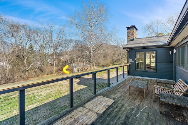 wooden deck featuring a lawn and a playground