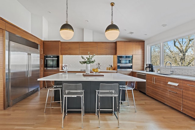 kitchen featuring stainless steel appliances, light countertops, and brown cabinets