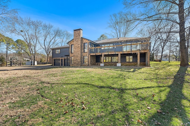 back of property featuring a garage, a lawn, stone siding, a chimney, and a deck