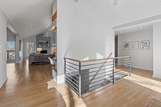 staircase with vaulted ceiling, baseboards, and wood finished floors