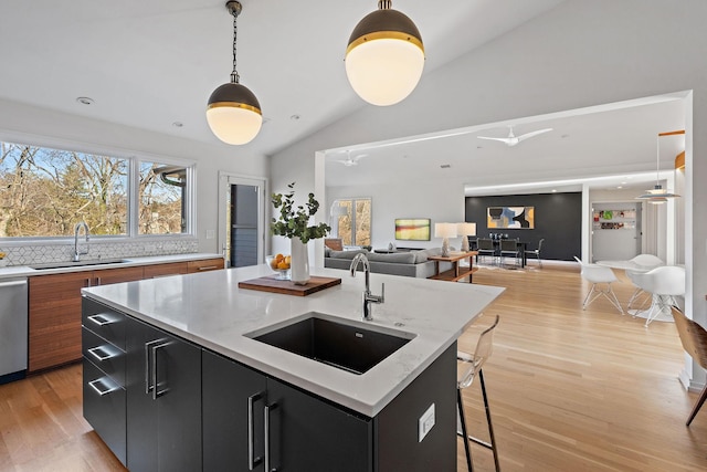 kitchen with dark cabinetry, pendant lighting, a sink, and a center island