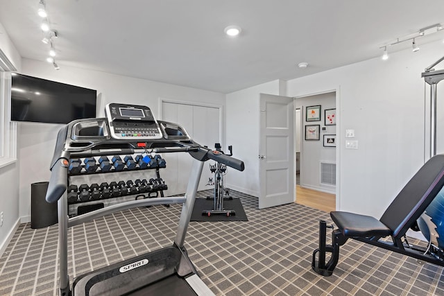 workout room with rail lighting, visible vents, and baseboards