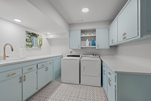 laundry area with a sink, visible vents, cabinet space, light floors, and washing machine and clothes dryer