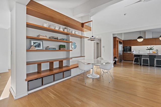 interior space featuring light wood-type flooring and vaulted ceiling with beams