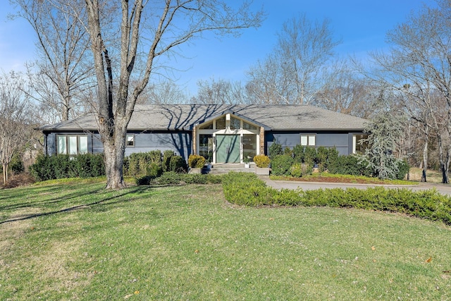 mid-century home featuring a front lawn