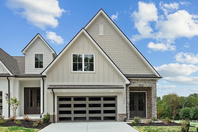 view of front of property with french doors, board and batten siding, driveway, and a shingled roof