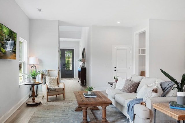 living room featuring recessed lighting, visible vents, light wood-style flooring, and baseboards