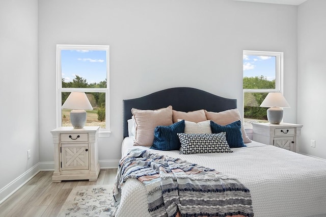 bedroom featuring baseboards and light wood finished floors