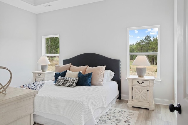 bedroom with visible vents, baseboards, and light wood-style floors