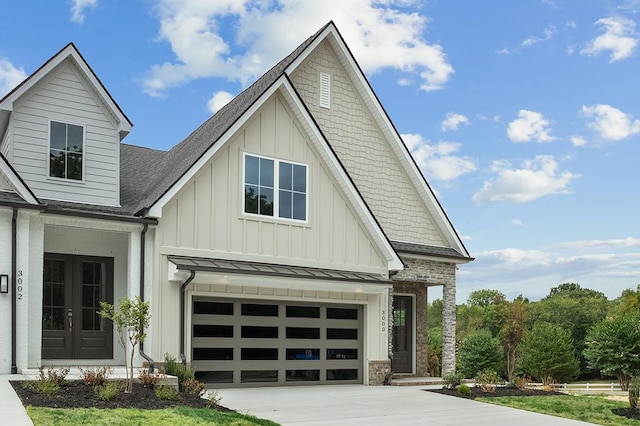 view of front facade with driveway, a standing seam roof, french doors, board and batten siding, and metal roof