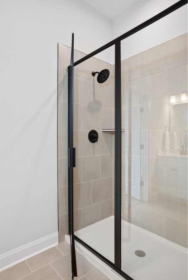 full bath with tile patterned floors, a shower stall, and baseboards