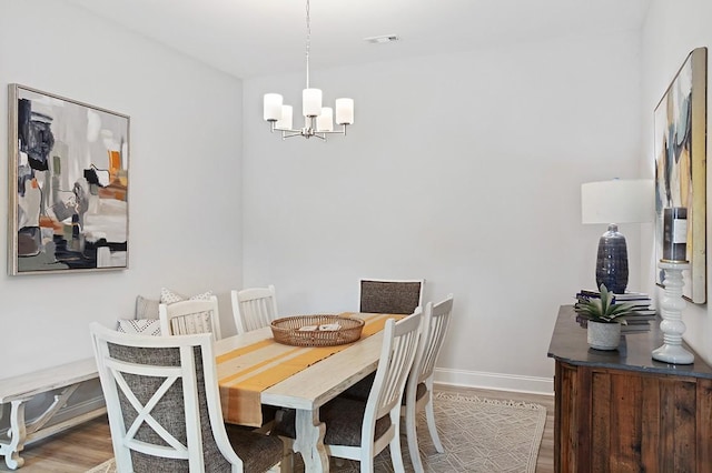 dining room with visible vents, baseboards, an inviting chandelier, and wood finished floors