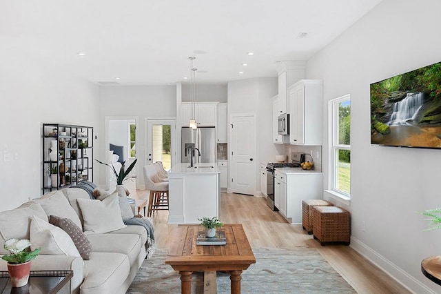 living room featuring recessed lighting, light wood-type flooring, and baseboards