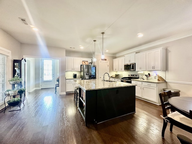 kitchen featuring stainless steel appliances, visible vents, a sink, and dark wood-style floors