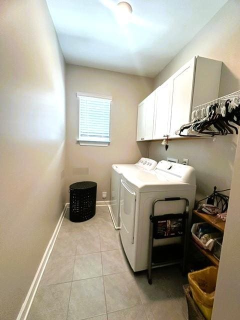 laundry room with light tile patterned floors, independent washer and dryer, cabinet space, and baseboards