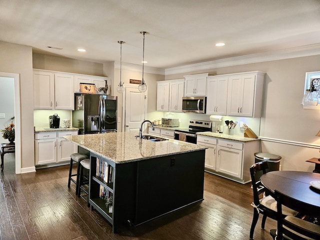 kitchen featuring appliances with stainless steel finishes, a sink, dark wood finished floors, and white cabinetry