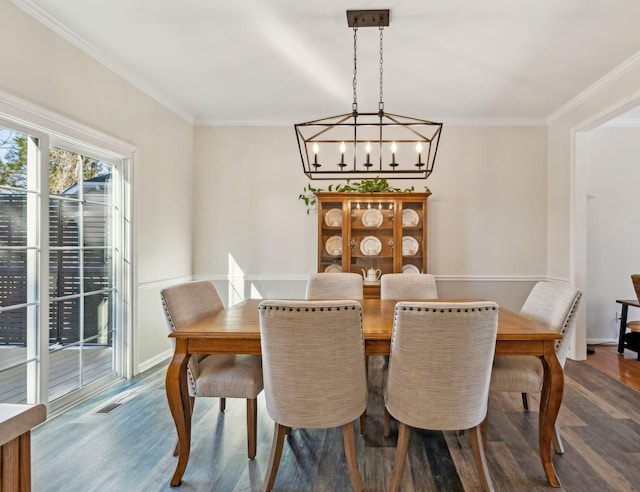 dining area featuring baseboards, ornamental molding, and wood finished floors