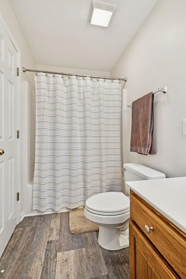 bathroom with toilet, visible vents, wood finished floors, and vanity