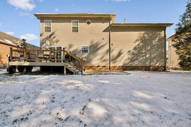 snow covered rear of property featuring crawl space and a deck